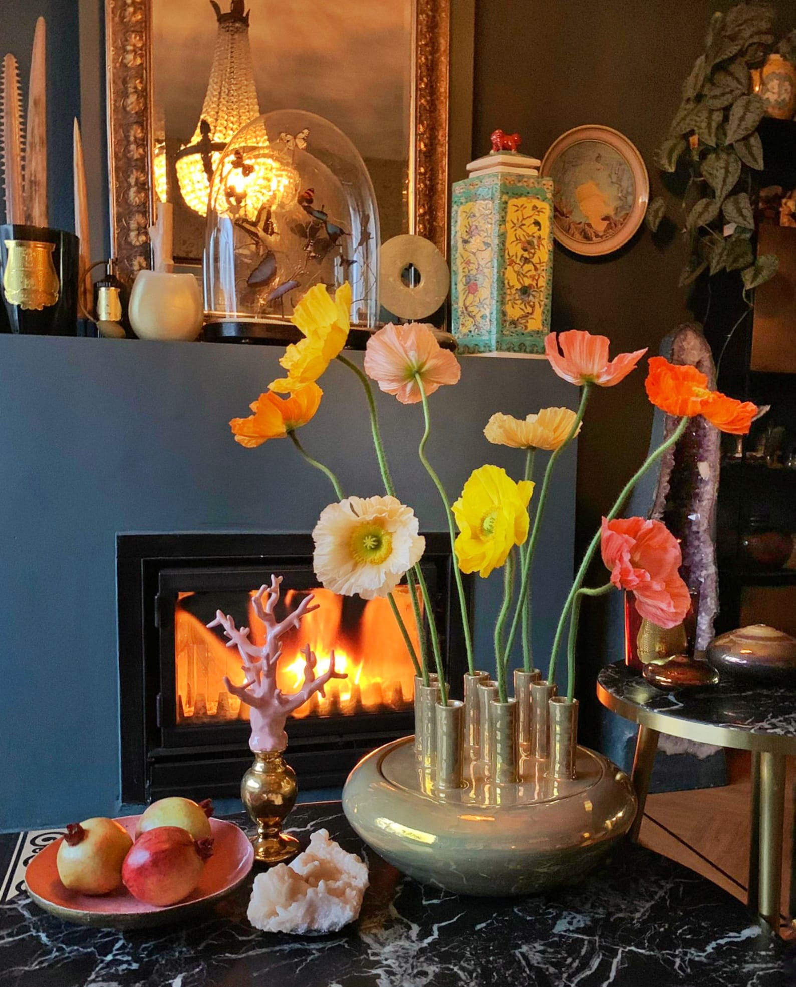 a cozy room with a fireplace in the background and a vase with nine silk plant flowers from florists den hague in a vase